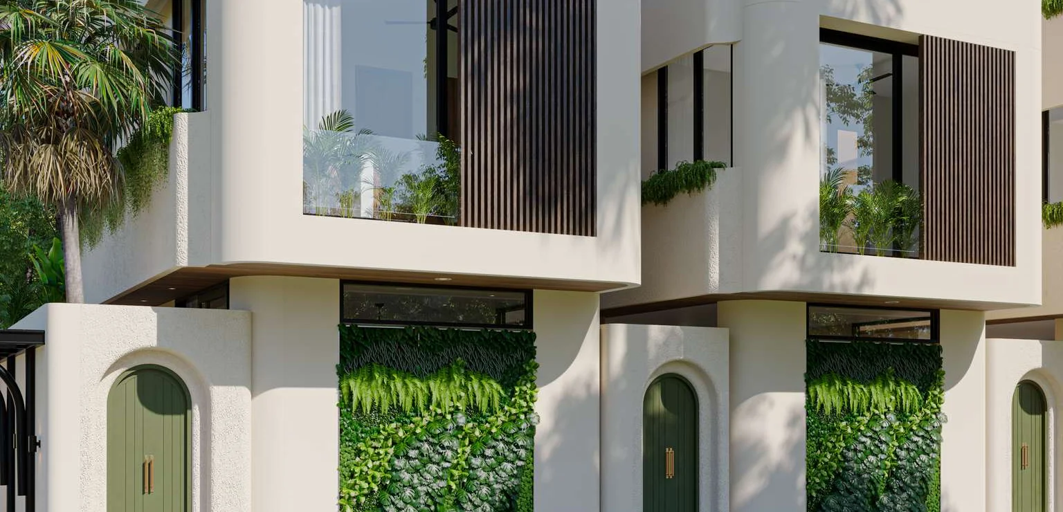 The row of houses in late sun: sand plaster, olive arched doors, ferns climbing the wall between them.